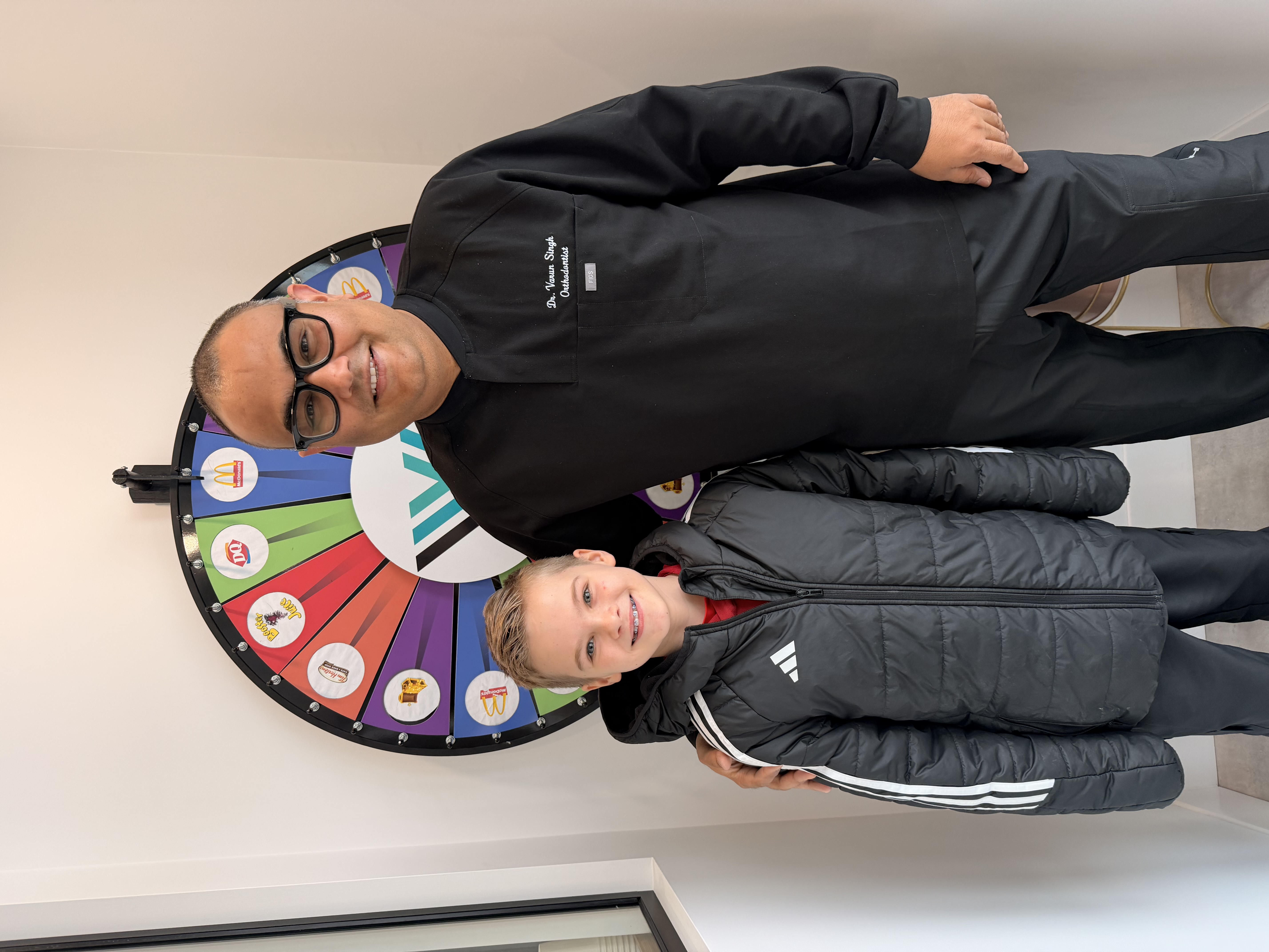 Young Vivid Smiles patient with Dr. Singh at the prize wheel