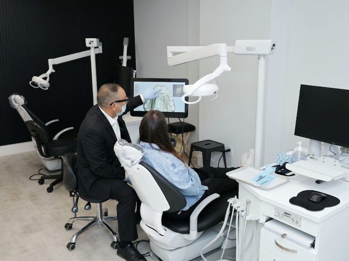 Dr. Singh performing a clinical exam in a modern Vivid Smiles treatment bay